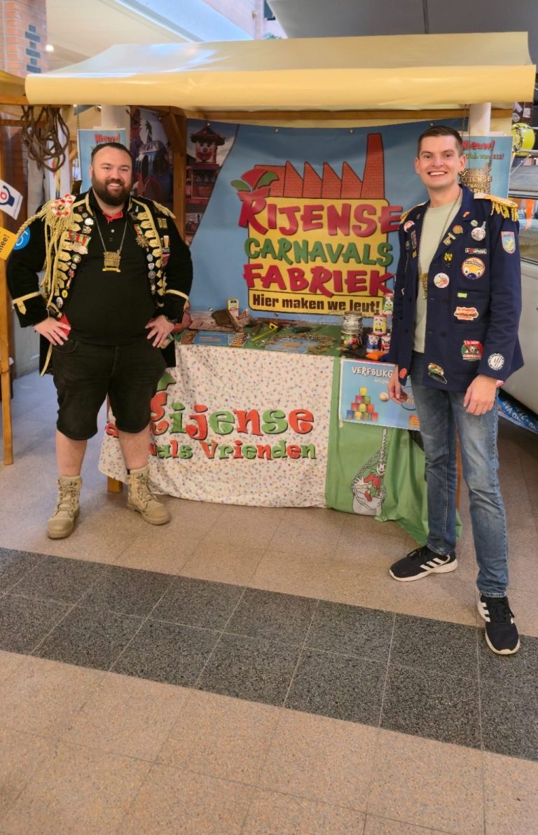 Twee mannen staan bij een kraam met kleurrijke decorations.